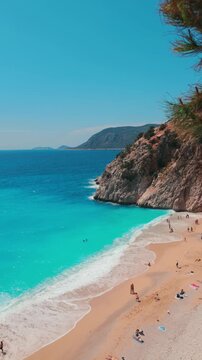 The famous "Kaputas Beach". Excellent nature and sea. People entering the sea and the beach. Beach umbrellas and sun beds. View of the beach from above. Kas region, Antalya, Turkey. 