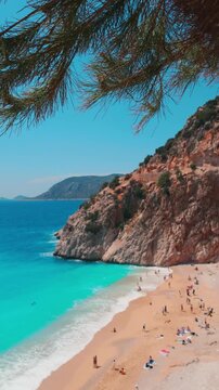 The famous "Kaputas Beach". Excellent nature and sea. People entering the sea and the beach. Beach umbrellas and sun beds. View of the beach from above. Kas region, Antalya, Turkey. 