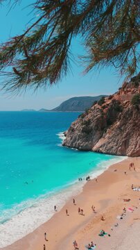 The famous "Kaputas Beach". Excellent nature and sea. People entering the sea and the beach. Beach umbrellas and sun beds. View of the beach from above. Kas region, Antalya, Turkey. 