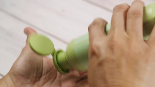 Video of hand getting lotion from bottle and rubbing it on the hands
