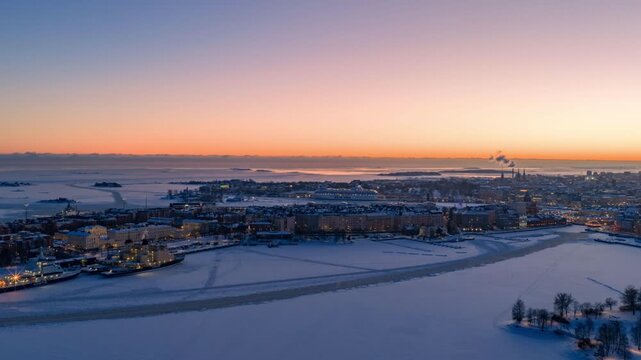 Drone hyperlapse Katajanokka blue hour Helsinki: frozen sea, Silja Line departure, snowy cityscape glowing. Crisp winter evening