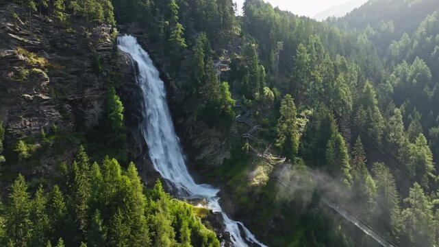 Aeril view waterfall in the Alps Stuibenfall Austria. Beautiful nature landscape mountain river flowing from a cliff in the landscape of rocky mountains. Travel and tourism in Europe.