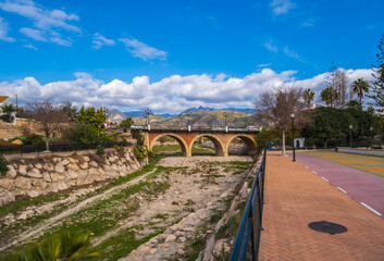 Ancient Arched Bridge Over Nerja Riverbed in Sunny Andalusian Valley