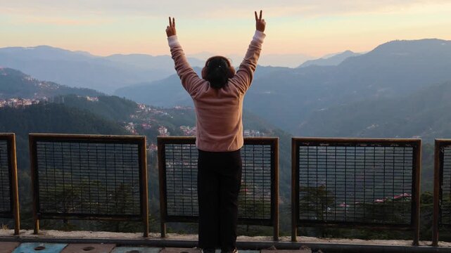 peaceful moment of woman with victory open arms in mountain landscape