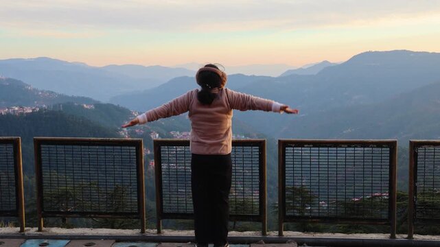 woman enjoying freedom at mountain viewpoint overlooking shimla hills