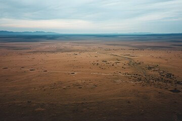 An aerial-style mountain and savanna landscape with a wide horizon and vast open grasslands. The clean composition and modern perspective make this background .