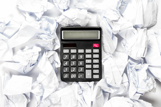 Regular calculator with crumpled sheets of paper.