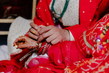 Romantic Tradition: Groom Adorn Bride with Bangles in Vivid Indian Wedding Rituals, Symbols of Love, Commitment, and Cultural Celebration, Close-up View