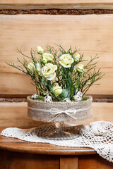 Florist at work: woman shows how to make simple Easter centerpiece with eustoma flowers, green...