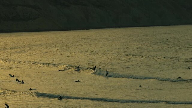 Sunset at Imsouane beach in Morocco with surfers in the lineup, cinematic ocean travel scene with calm evening light
