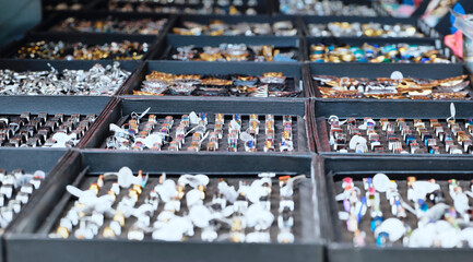 Hands browsing Indian jewelry stall, choosing rings at a vibrant market