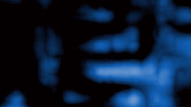 Blurry blue shapes on a dark background.