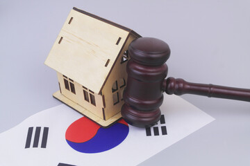 Judge gavel and house model on flag of South Korea. Real estate, laws and court in Korea.