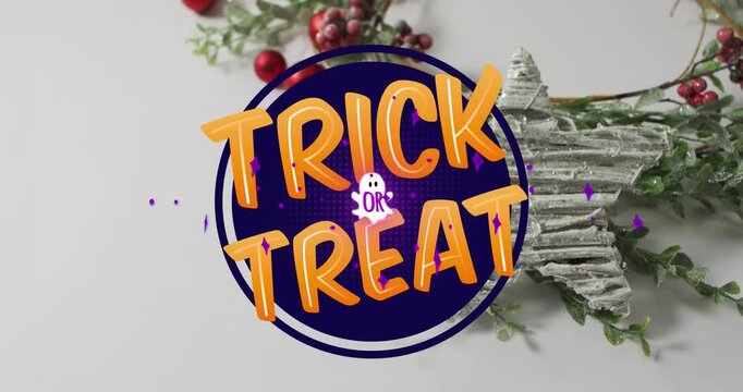Animation of trick or treat text over christmas decorations