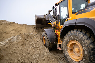 Yellow Wheel Loader Moving Sand