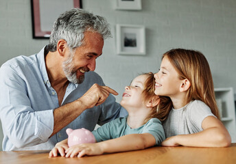 Grandparent grandfather And His Grandson and granddaughter Putting Coin Money In Piggybank  At...