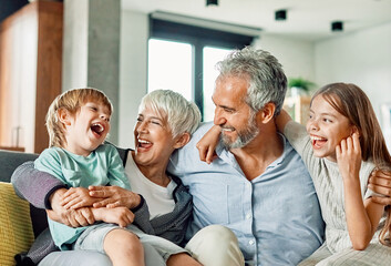 Portrait of grandparents and grandchildren having fun together at home