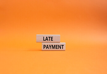 Late payment symbol. Concept word Late payment on wooden blocks. Beautiful orange background....