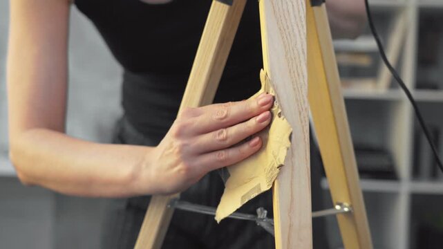 DIY - Do It Yourself. Young woman renovating and painting a design lamp at home. Renewing, tinkering, home improvement.