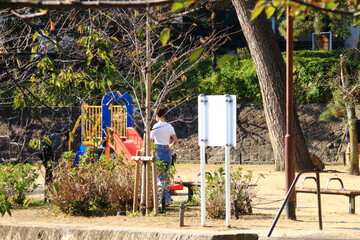 日本の公園のすべり台の前に立つ人