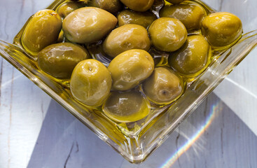 glass bowl filled with green olives