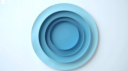 Three circular blue plates of varying sizes arranged symmetrically on a white surface.