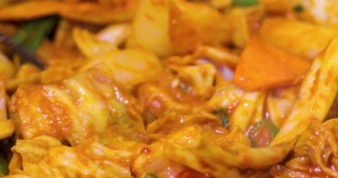 The Korean-style spicy stir-fried spring chicken, tossed on a heated iron plate, has an enticing reddish-brown color, creating a delicious atmosphere perfect for sharing during a meal.