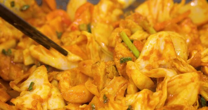 The Korean-style spicy stir-fried spring chicken, tossed on a heated iron plate, has an enticing reddish-brown color, creating a delicious atmosphere perfect for sharing during a meal.