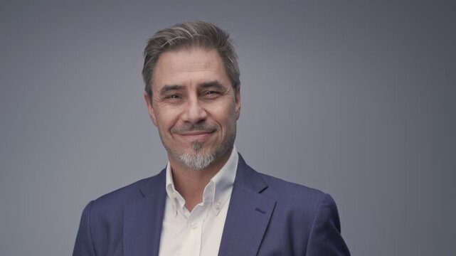 Business portrait - businessman smiling, jacket and open collar white shirt. Mature age, middle age, mid adult man in 50s with gray hair and happy confident smile. Copy space.