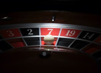 Obraz premium Close-up of Roulette Wheel with White Ball on Red Number Seven Slot