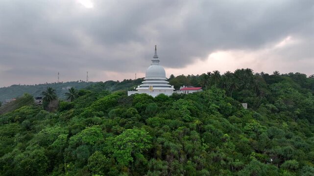Drone aerial landscape of Japanese Peace Pagoda Buddhism temple tower monastery building Rumassala overlooking headland coastline forest Unawatuna Galle Sri Lanka Asia religion tourism travel