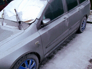 Eis und Eiszapfen an einem zugefrorenen Fahrzeug
