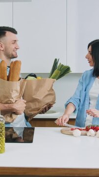 Attractive happy smiling couple gethering to cook family dinner together on modern cuisine