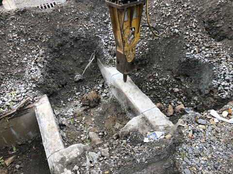 Abbrucharbeiten mit einem gro&szlig;en Meisel auf einer Baustelle