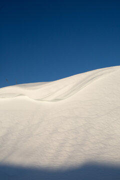 Pure White Snow Drifts Against Deep Blue Sky