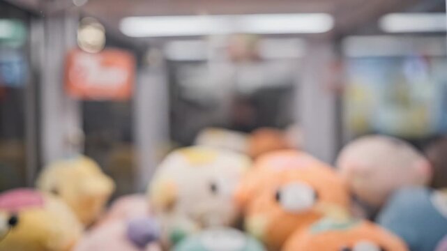 Closeup medium shot of a small robotic arms gripper securely holding a plush prize with the rest of the claw machine prizes becoming a dreamy bokeh.