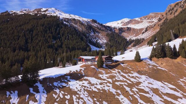 Bort Gondola Lift Cable Car Station on Sunny Winter Day. Swiss Alps. Grindelwald, Switzerland. Aerial Drone Shot. Moving Forward