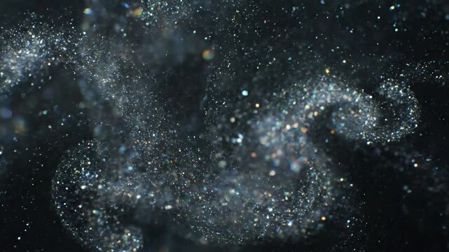 Abstract Particle Dynamics Focus on the intricate, ever-changing patterns and the seemingly endless flow of the micro-glitter particles, creating a sense of infinite, organic movement against a dark