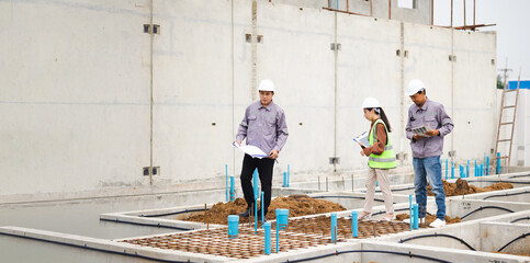 Fototapeta premium Reinforced concrete structures. Man and woman construction worker working together at workplace. Group of professional construction engineering people in hardhat safety helmet. Unity and teamwork