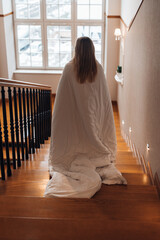 Woman Descending Stairs Wrapped in a Blanket