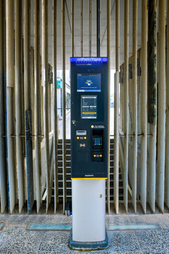 Sliema, Malta - February 1, 2026: A modern Skidata parking payment machine stands in a parking garage entrance with a vertical slat wall background, providing automated ticket services.