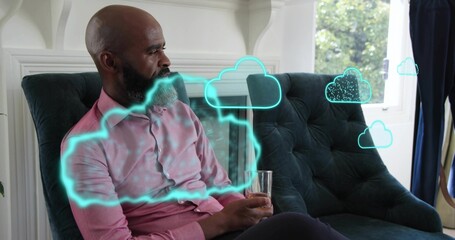 Naklejka premium Sitting man in pink shirt holding glass on teal chair at home, neon-cyan clouds floating