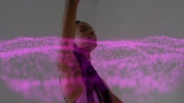 Woman with bent right arm performing torso flow in studio performance, magenta band revealing face