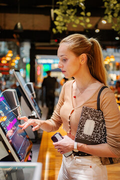 Woman using self service touchscreen kiosk in Vienna