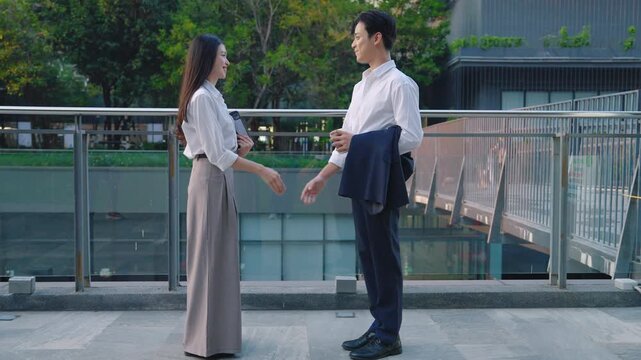 Two business colleagues shaking hands on a modern urban skywalk after a successful meeting, symbolizing partnership, agreement, and professional cooperation.
