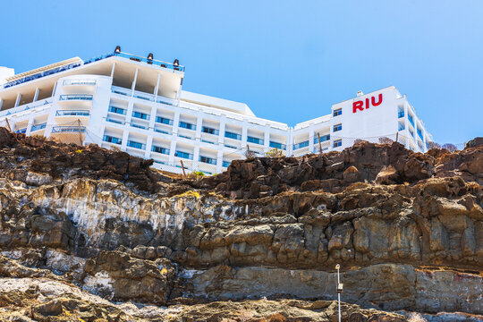 Close up view of RIU hotel building standing on rocky cliff with safety net installed along edge of hotel territory. Gran Canaria. Spain.