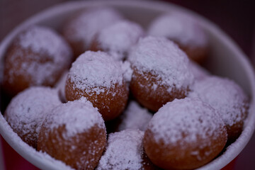 Donuts or doughnuts are made from a mixture of flour, sugar, egg yolks, yeast, and butter. Ball shaped, powdered sugar on a stacked donut