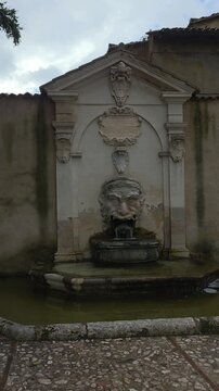 The Mascherone Fountain in Spoleto is a 17th-century stone landmark in Piazza Campello, featuring a grotesque laurel-crowned mask spitting fresh water