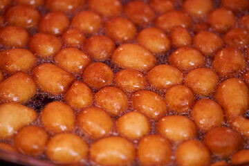 Donuts or doughnuts are made from a mixture of flour, sugar, egg yolks, yeast, and butter. Ball shaped, powdered sugar on a stacked donut