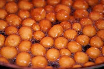 Donuts or doughnuts are made from a mixture of flour, sugar, egg yolks, yeast, and butter. Ball shaped, powdered sugar on a stacked donut